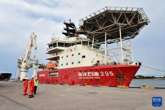 8月8日，在文萊摩拉港碼頭，工作人員站在“海洋石油295”船前。新華社記者 李萌 攝