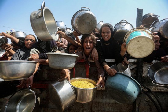 　　8月10日，在加沙城，民眾領(lǐng)取免費食物。新華社發(fā)（里澤克·阿卜杜勒賈瓦德攝）