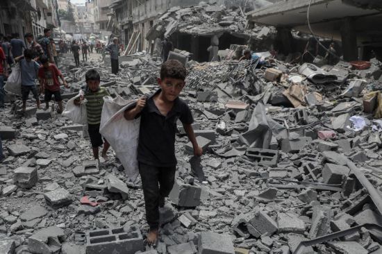 　　8月8日，孩子們在加沙城以軍襲擊后的廢墟上搬運物品。新華社發(fā)（里澤克·阿卜杜勒賈瓦德攝）