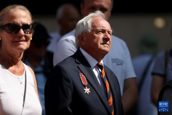 8月15日，人們站在英國(guó)倫敦和平紀(jì)念碑前參加默哀儀式。新華社記者 李穎 攝