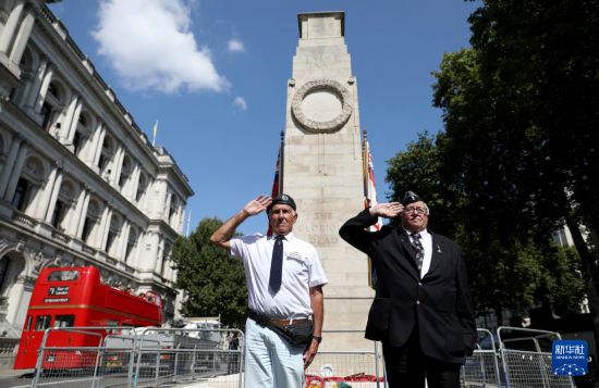   8月15日，在英國(guó)倫敦和平紀(jì)念碑前，兩名老兵向在戰(zhàn)爭(zhēng)中犧牲的人們致敬。新華社記者 李穎 攝