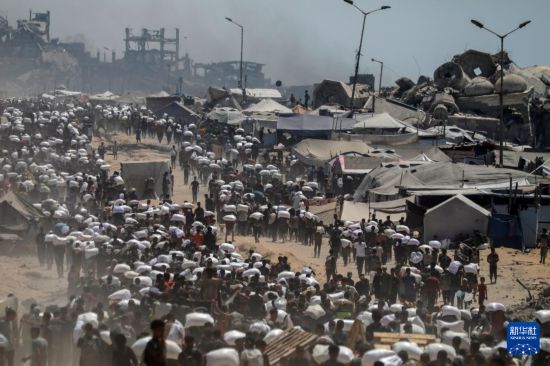 　　7月27日，在加沙地帶北部城鎮(zhèn)拜特拉希亞，人們領(lǐng)取通過邊境口岸進(jìn)入加沙的援助物資。新華社發(fā)（里澤克·阿卜杜勒賈瓦德攝）
