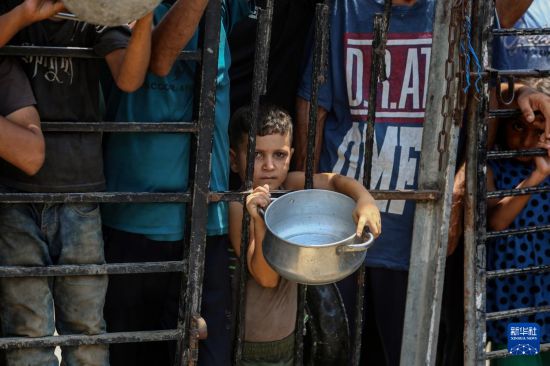 　　8月10日，流離失所的巴勒斯坦人在加沙城西部等待領(lǐng)取食物。新華社發(fā)（里澤克·阿卜杜勒賈瓦德攝）