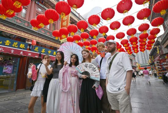 8月14日，上合組織國(guó)家學(xué)生在天津古文化街留影。新華社記者李然攝