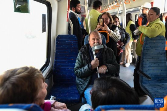 8月25日，在智利圣地亞哥首都大區(qū)倫卡市，當(dāng)?shù)孛癖娺M(jìn)入簽約儀式現(xiàn)場(chǎng)停放的一輛中國(guó)制造的列車內(nèi)參觀。新華社發(fā)（豪爾赫·比列加斯攝）