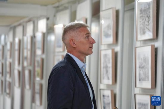 8月28日，在俄羅斯圣彼得堡，一名男子參觀紀(jì)念中國人民抗日戰(zhàn)爭暨世界反法西斯戰(zhàn)爭勝利80周年圖片展。新華社記者 周天翮 攝