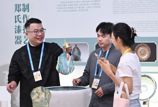 在2025年上海合作組織峰會新聞中心非遺互動展示區(qū)，鄭勇向參觀者演示漂流漆技法。新華社記者李然攝