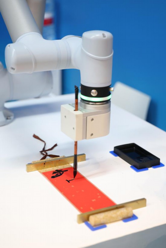 在2025年上海合作組織峰會(huì)新聞中心，智能機(jī)器人進(jìn)行書法展示。新華社記者楊青攝