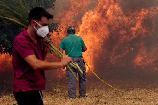 8月18日，在西班牙奧倫塞附近村莊，當(dāng)?shù)鼐用駞⑴c滅火作業(yè)。新華社/美聯(lián)