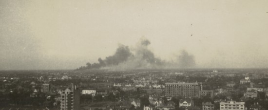 這是一張此次捐贈照片掃描件的局部，記錄下滬西地區(qū)遭轟炸的受損情況，鄔達克設計的著名建筑諾曼底公寓（今徐匯區(qū)武康大樓）位于畫面中間偏右一側。（受訪專家團隊提供）