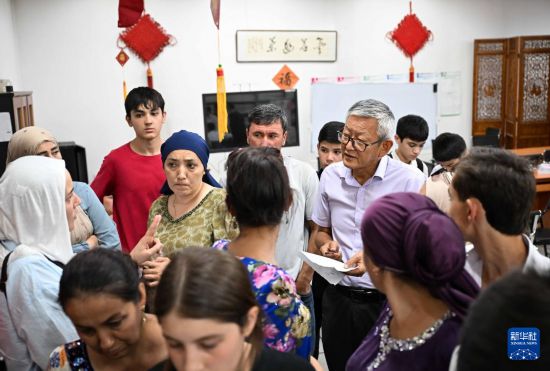 9月12日，在塔吉克斯坦首都杜尚別的國家圖書館中國廳，李建軍老師（中右）在報名現(xiàn)場和學(xué)生家長交流。新華社記者 李任滋 攝