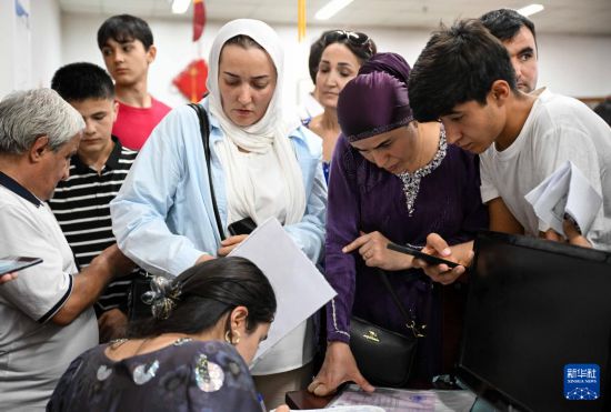 9月12日，在塔吉克斯坦首都杜尚別的國家圖書館中國廳，學(xué)生家長在為孩子報名。新華社記者 李任滋 攝