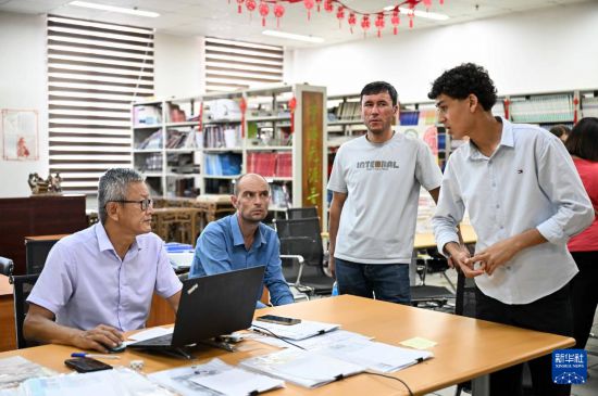 9月12日，在塔吉克斯坦首都杜尚別的國家圖書館中國廳，17歲的阿卜杜拉希姆（右一）與李建軍老師（左一）用中文交流。新華社記者 李任滋 攝