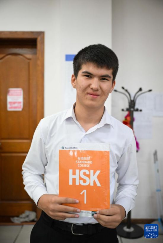 9月12日，在塔吉克斯坦首都杜尚別的國家圖書館中國廳，一名學(xué)生展示中文課所用教材。新華社記者 李任滋 攝