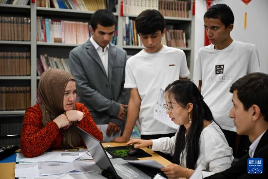 9月12日，在塔吉克斯坦首都杜尚別的國家圖書館中國廳，王惠娟老師（前右二）在報名現(xiàn)場工作。新華社記者 李任滋 攝