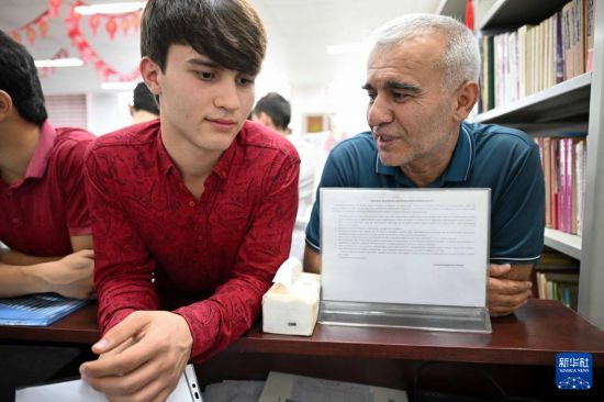 9月12日，在塔吉克斯坦首都杜尚別的國家圖書館中國廳，拉蘇爾（左）在父親的帶領(lǐng)下前來報名。新華社記者 李任滋 攝