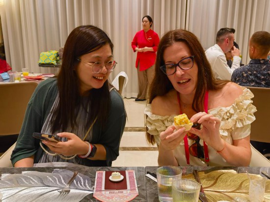 9月14日，入境游客對(duì)一款小吃很感興趣，展開討論。新華社記者 陳愛平 攝