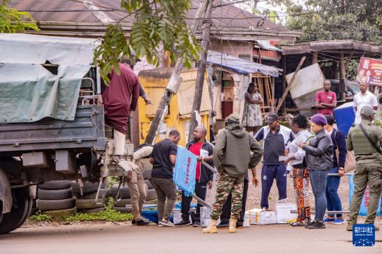 　　10月12日，在喀麥隆西南大區(qū)首府布埃亞，選舉工作人員和安保人員在投票站開放前準備投票材料。新華社發(fā)（穆朗·廷古姆攝）
