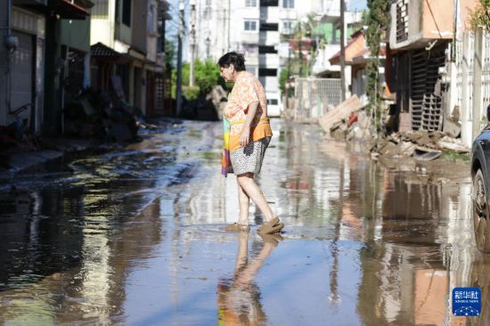 　　10月12日，在墨西哥韋拉克魯斯州波薩里卡，一名婦女走過泥濘積水的街道。新華社發(fā)（弗朗西斯科·卡涅多攝）