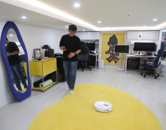 2025年10月13日，韓國消費(fèi)者在首爾的家中使用掃地機(jī)器人。新華社記者姚琪琳攝