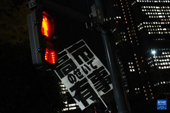 11月21日，在日本東京的首相官邸外，民眾舉起標(biāo)語(yǔ)參加抗議活動(dòng)。新華社記者 賈浩成 攝