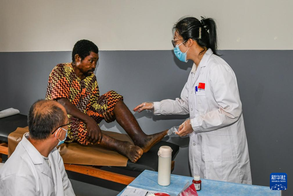7月24日，在喀麥隆首都雅溫得郊外的阿法諾亞村，中國(guó)援喀麥隆醫(yī)療隊(duì)隊(duì)員為當(dāng)?shù)鼗颊咦鰴z查。新華社發(fā)（科普索攝）