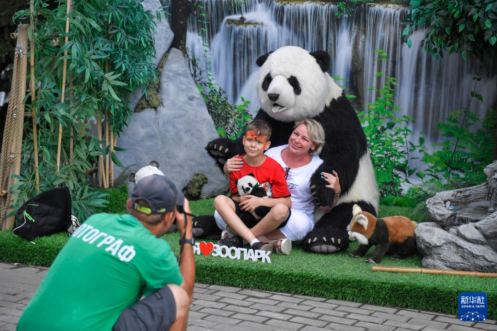 7月30日，在俄羅斯莫斯科動(dòng)物園，游客與大熊貓模型合影。新華社發(fā)（亞歷山大攝）