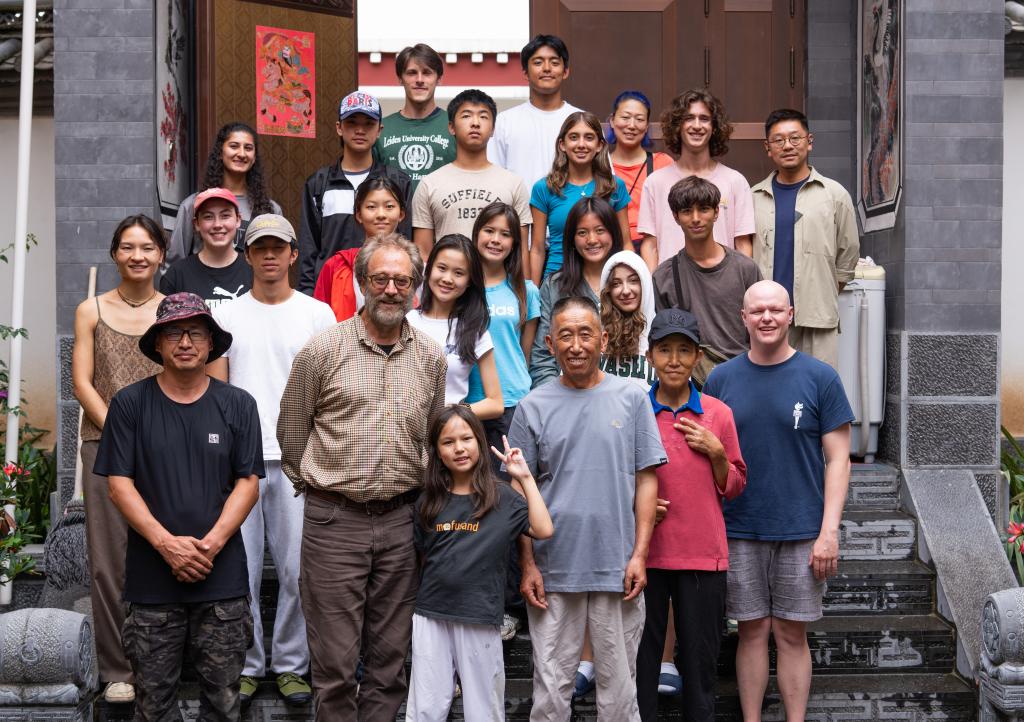 7月26日，在云南省迪慶藏族自治州德欽縣燕門鄉(xiāng)茨中村一戶村民家中，約翰·弗勞爾（前排左二）與美國青少年團隊同村民（前排右二、右三）合影。新華社記者 高詠薇 攝