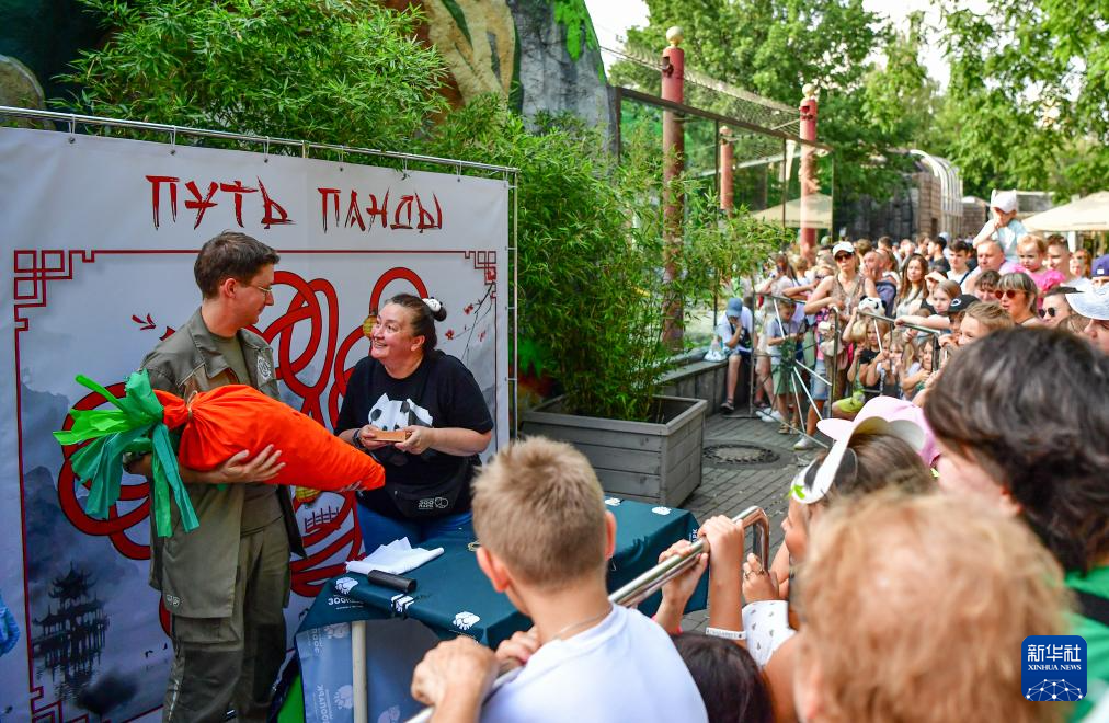 7月31日，在俄羅斯莫斯科動(dòng)物園，工作人員和游客為大熊貓“如意”制作生日禮物。新華社記者 張超群 攝