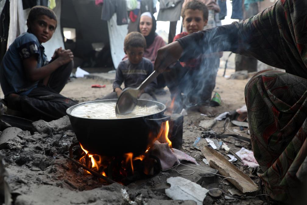 7月29日，在加沙城的一個帳篷里，孩子們在食物旁等待。新華社發(fā)（里澤克·阿卜杜勒賈瓦德攝）