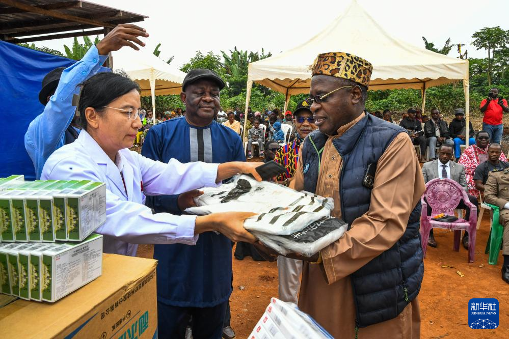 7月24日，在喀麥隆首都雅溫得郊外的阿法諾亞村，中國(guó)援喀麥隆醫(yī)療隊(duì)隊(duì)員向當(dāng)?shù)厝税l(fā)放醫(yī)療物資。新華社發(fā)（科普索攝）