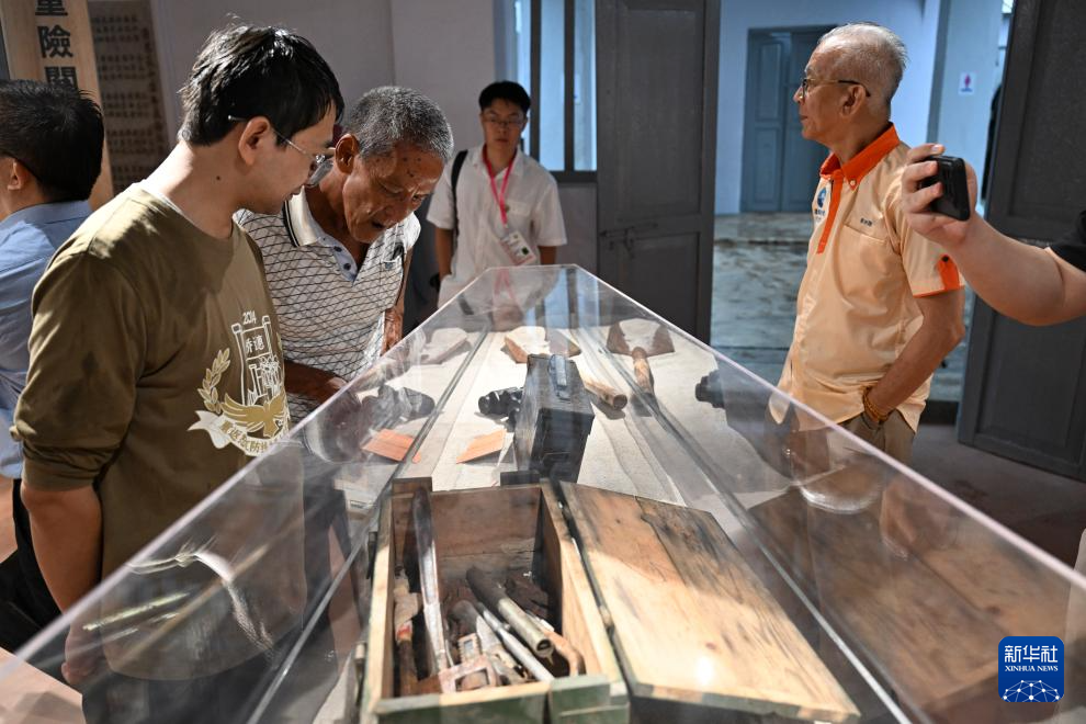 8月14日，在馬來西亞吉隆坡南僑機(jī)工紀(jì)念館內(nèi)，參觀者查看南僑機(jī)工們使用過的修路工具。新華社記者 程一恒 攝