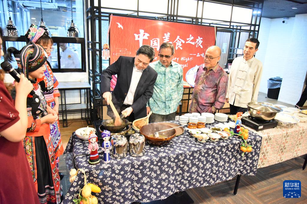 8月23日，在文萊首都斯里巴加灣市的拉克薩馬納商學院，嘉賓在“中國美食之夜——品味廣西”活動上體驗廣西炒茶。新華社記者 李萌 攝